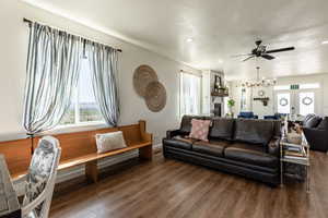 Living room with french doors, a fireplace, dark hardwood / wood-style flooring, and ceiling fan with notable chandelier