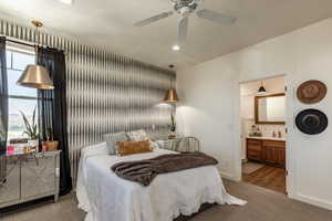 Carpeted bedroom featuring ceiling fan, sink, and connected bathroom