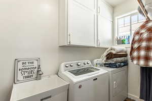 Laundry room with cabinets, sink, and washing machine and clothes dryer