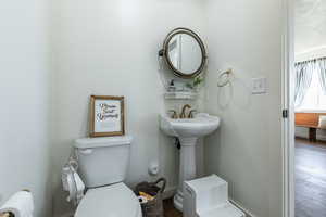 Bathroom with toilet and wood-type flooring