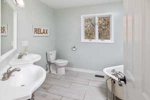 Bathroom featuring toilet, wood-type flooring, and sink