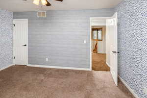 Spare room with ceiling fan and carpet floors