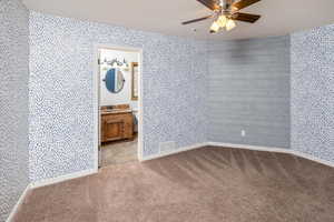 Carpeted spare room with a textured ceiling, ceiling fan, and sink