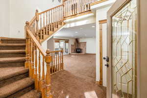 Carpeted foyer with a wood stove