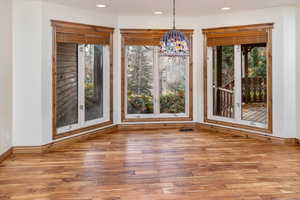 Unfurnished dining area featuring hardwood / wood-style floors