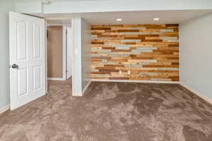 Empty room with carpet flooring and wooden walls