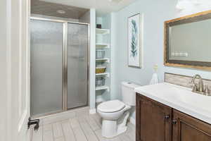 Bathroom with vanity, toilet, and a shower with door