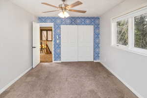 Unfurnished bedroom with carpet flooring and ceiling fan