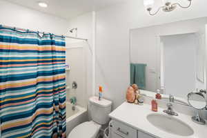 Full bathroom featuring shower / tub combo, vanity, and toilet