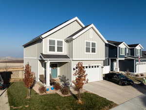 View of front of house with a mountain view, a front lawn, and a garage