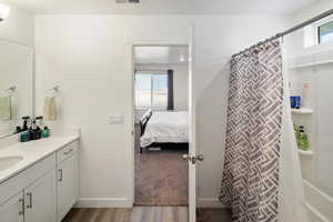 Bathroom with a shower with shower curtain, vanity, and wood-type flooring