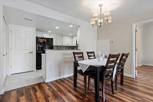 Dining room featuring dark hardwood / wood-style floors and a notable chandelier