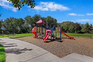 View of playground featuring a lawn