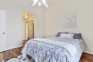 Bedroom with ceiling fan and dark wood-type flooring