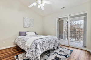 Bedroom with ceiling fan, wood-type flooring, access to outside, and vaulted ceiling