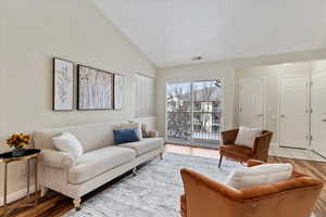 Living room featuring high vaulted ceiling and light hardwood / wood-style floors