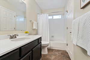 Full bathroom with shower / tub combo with curtain, vanity, and toilet