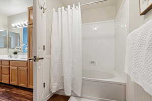 Bathroom featuring vanity, wood-type flooring, and shower / tub combo with curtain