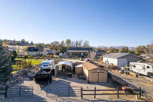 Rear view of property featuring a mountain view and a storage unit