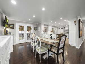 Dining room featuring sink, french doors, dark wood-type flooring, and ornamental molding