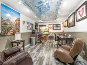 Office area with hardwood / wood-style floors and rail lighting