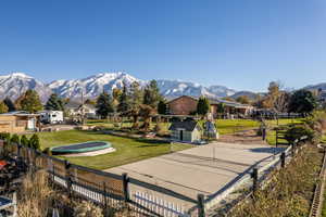 Surrounding community with a mountain view and a yard