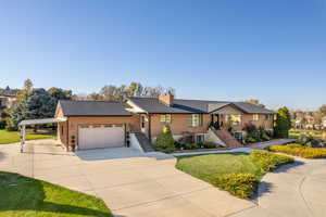 Ranch-style house with a garage and a front lawn