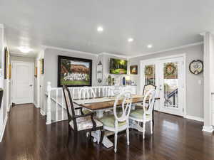 Dining area with french doors, dark hardwood / wood-style flooring, and crown molding