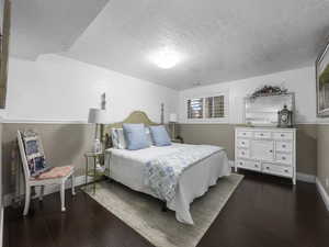 Bedroom featuring dark hardwood / wood-style floors and a textured ceiling