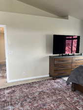 Bedroom with carpet and lofted ceiling