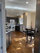 Kitchen with a textured ceiling, dark hardwood / wood-style flooring, and white appliances