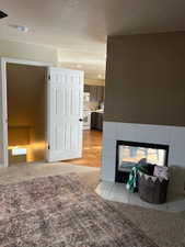 Interior space featuring a textured ceiling and light colored carpet