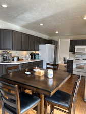 Kitchen featuring white appliances, a textured ceiling, and light hardwood / wood-style flooring