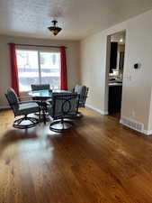 Dining space featuring hardwood / wood-style flooring and a textured ceiling