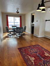 Dining space with wood-type flooring and a textured ceiling