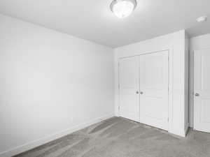 Unfurnished bedroom featuring a closet and carpet floors