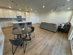 Dining area with ceiling fan and light hardwood / wood-style floors