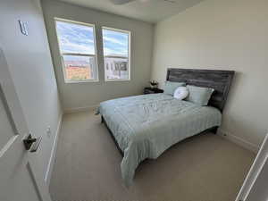 Carpeted bedroom featuring ceiling fan