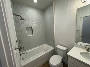 Full bathroom with vanity, toilet, and tiled shower / bath