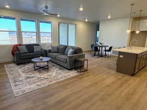 Living room featuring ceiling fan, light wood-type flooring, and sink