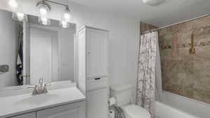 Full bathroom featuring shower / bath combination with curtain, toilet, and vanity