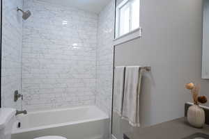 Bathroom featuring toilet and tiled shower / bath