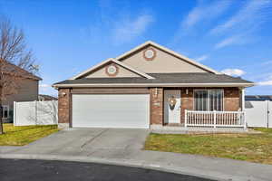 Single story home featuring a porch, a garage, and a front lawn