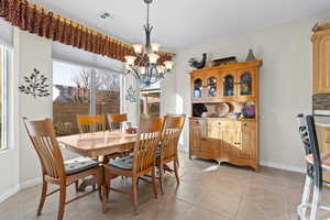 Bright dining area with an inviting chandelier and light tile patterned flooring