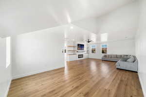 Unfurnished living room with ceiling fan and light hardwood / wood-style flooring