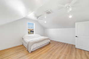 Bedroom with ceiling fan, vaulted ceiling, and light hardwood / wood-style flooring