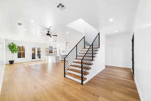 Stairway featuring hardwood / wood-style floors, ceiling fan, and french doors