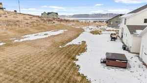 Yard layered in snow featuring central air condition unit, a water and mountain view, and a hot tub