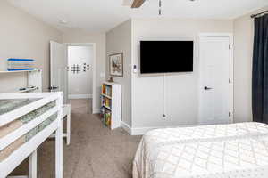 Bedroom with ceiling fan and light colored carpet