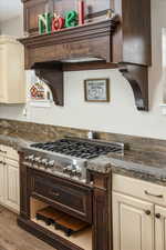 Kitchen featuring stainless steel gas stovetop, light hardwood / wood-style flooring, and cream cabinets